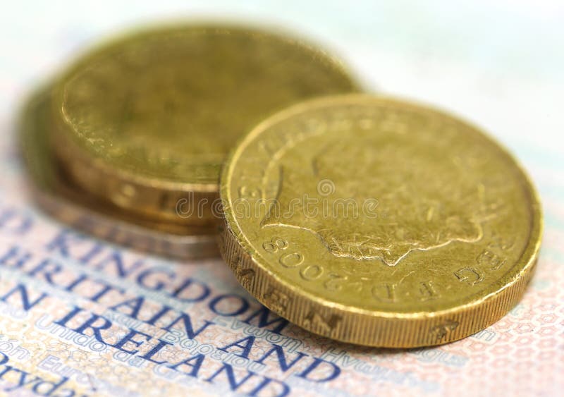 Pièce de monnaie de livre britannique sur un passeport photo stock Pièce de monnaie de livre britannique sur un passeport photo stock