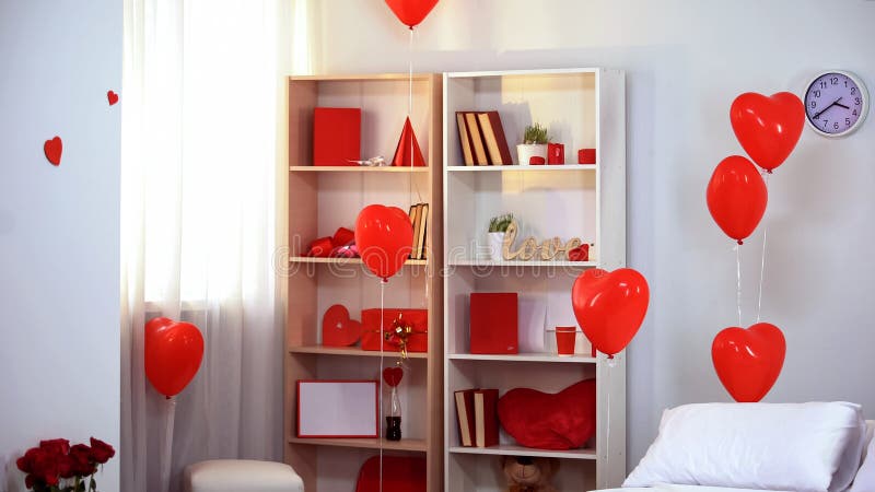 Pièce décorée des ballons en forme de coeur rouges, surprise romantique, studio de photo photo libre de droits Pièce décorée des ballons en forme de coeur rouges, surprise romantique, studio de photo photo libre de droits