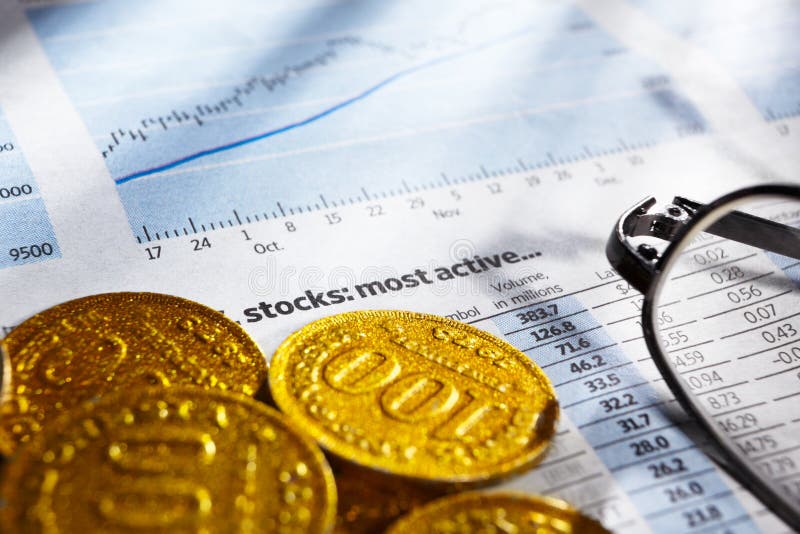 Gold coins and glasses on top of stock data report. Gold coins and glasses on top of stock data report