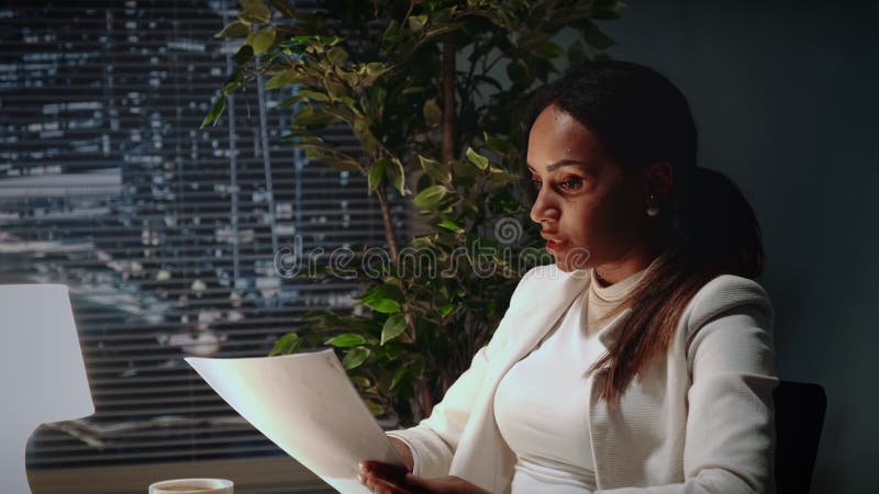 Beautiful african american business women explaining the text of contract in office. There are skyscrapers in the background. Beautiful african american business women explaining the text of contract in office. There are skyscrapers in the background.