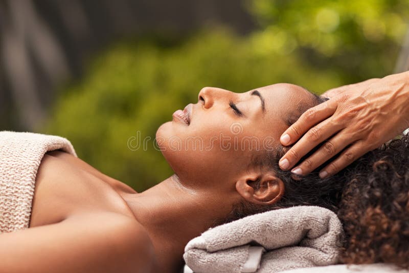 Beautiful black women getting face massage in luxury spa. African american girl relaxing in resort spa while getting head massage. Masseuse hands massaging beauty black women with closed eyes at outdoor spa. Beautiful black women getting face massage in luxury spa. African american girl relaxing in resort spa while getting head massage. Masseuse hands massaging beauty black women with closed eyes at outdoor spa