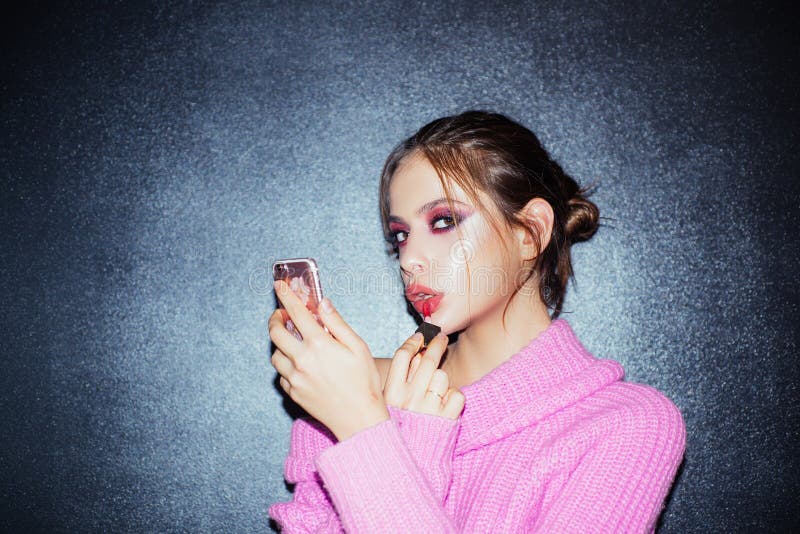 Piękna bloger Dziewczyna z pomadk? na wargach dziewczyna używa telefon jak lustro stawiający lipgloss Moda portret kobieta makeup zdjęcie stock Piękna bloger Dziewczyna z pomadk? na wargach dziewczyna używa telefon jak lustro stawiający lipgloss Moda portret kobieta makeup zdjęcie stock
