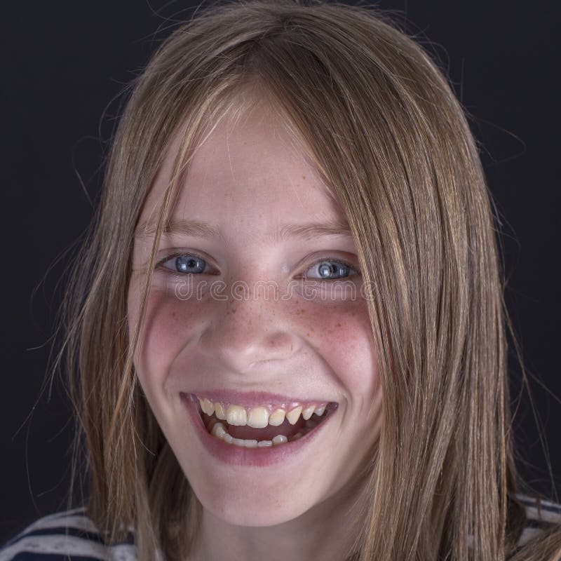 Piękna blond młoda dziewczyna z piegami indoors na czarnym tle, zbliżenie portret zdjęcie royalty free Piękna blond młoda dziewczyna z piegami indoors na czarnym tle, zbliżenie portret zdjęcie royalty free