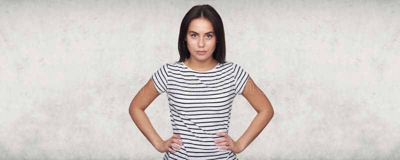 Piękna, brunetka, stojąca przed szare betonowe studio zdjęcia royalty free Piękna, brunetka, stojąca przed szare betonowe studio zdjęcia royalty free