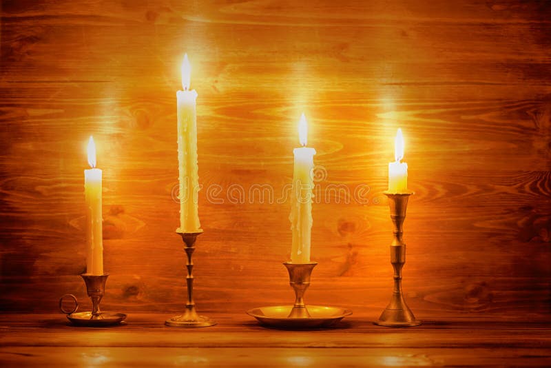 Piękna cztery świeczki z różnymi roczników candlesticks na wo fotografia stock Piękna cztery świeczki z różnymi roczników candlesticks na wo fotografia stock