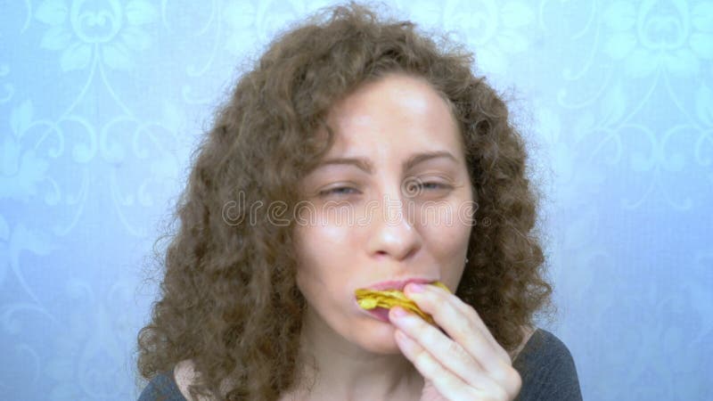 Piękna dziewczyna curry z przyjemnością je chipsy ziemniaczane. portret