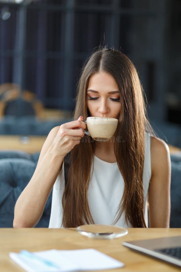 Piękna dziewczyna i filiżanka cappuccino zdjęcia stock Piękna dziewczyna i filiżanka cappuccino zdjęcia stock