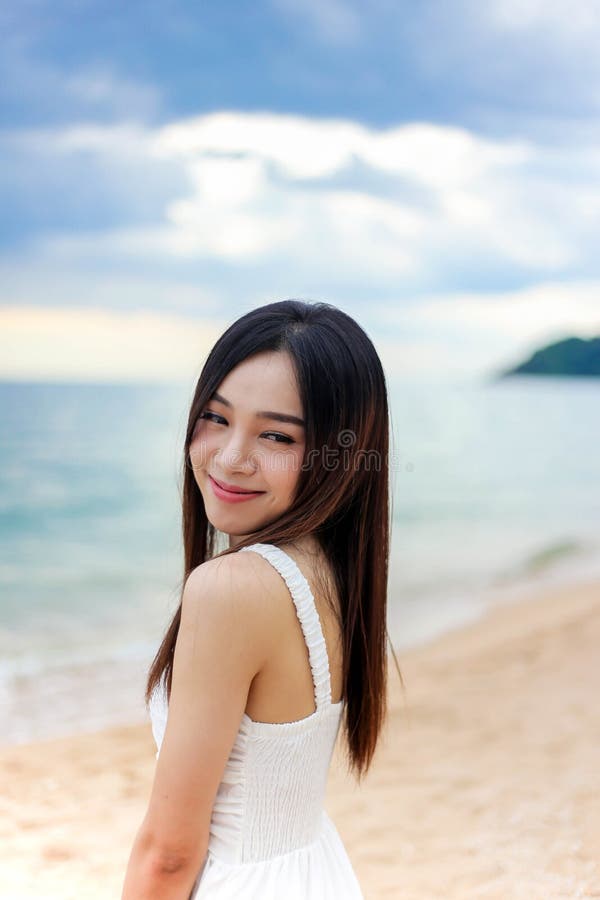 Piękna dziewczyna, młoda kobieta, stojąca w wodzie na piaszczystej plaży o zachodzie słońca, cieszy się letnimi wakacjami na plaż fotografia stock Piękna dziewczyna, młoda kobieta, stojąca w wodzie na piaszczystej plaży o zachodzie słońca, cieszy się letnimi wakacjami na plaż fotografia stock