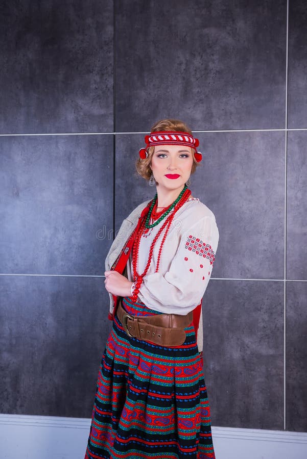 Piękna dziewczyna w Krajowym Ukraińskim kostiumu Chwytający w studiu Broderia i kurtka wianek Circlet kwiaty czerwone usta zdjęcie royalty free Piękna dziewczyna w Krajowym Ukraińskim kostiumu Chwytający w studiu Broderia i kurtka wianek Circlet kwiaty czerwone usta zdjęcie royalty free