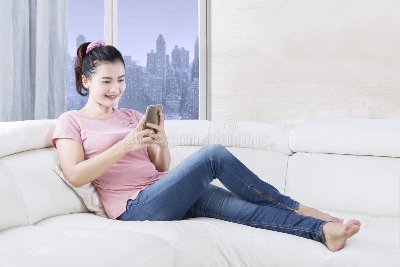 Piękna kobieta używa smartphone w domu zdjęcie stock Piękna kobieta używa smartphone w domu zdjęcie stock