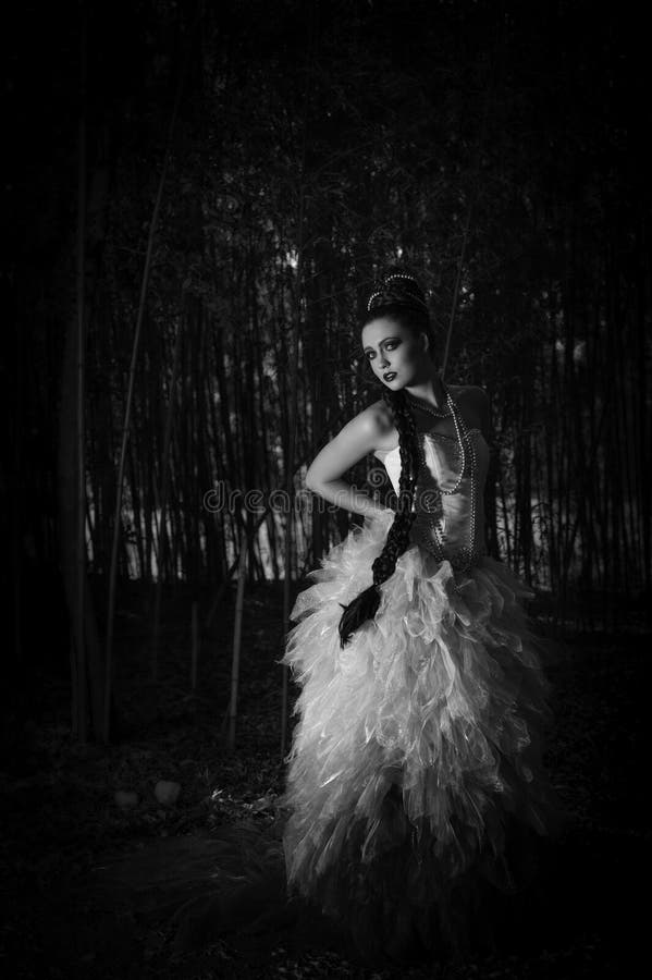 Piękna kobieta w modach ubiera pozycję w lesie