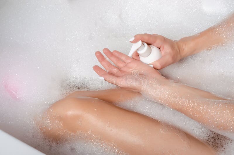 Piękna kobieta w skąpanie piany piękna zdrowie nogach w ręki whitw butelki gel prysznic kosmetycznym szamponie obrazy stock Piękna kobieta w skąpanie piany piękna zdrowie nogach w ręki whitw butelki gel prysznic kosmetycznym szamponie obrazy stock