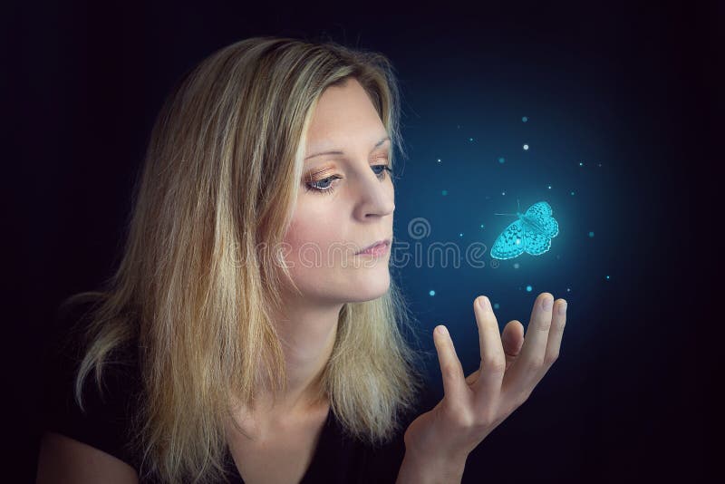 Beauty young blond hair woman hold hand under glowing blue butterfly. Photomanipulation glowing lepidopteran on black background. Beauty young blond hair woman hold hand under glowing blue butterfly. Photomanipulation glowing lepidopteran on black background.