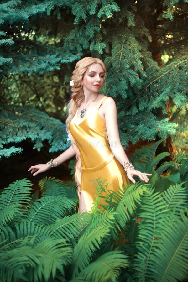 Piękna młoda blondyna kobieta z bardzo długimi włosami, która jest spleciona. dziewczyna jest ubrana w uwodzicielską żółtą sukienk