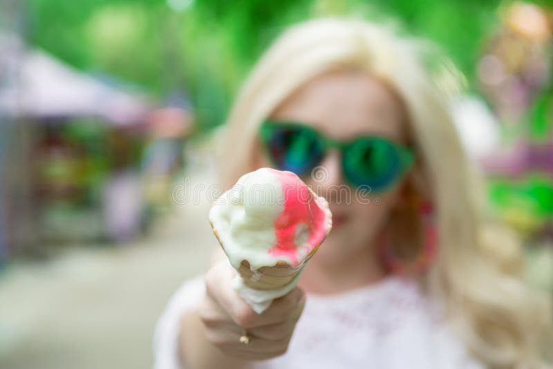 Piękna, młoda blondynki dziewczyna z lody w jej rękach, liźnięcia lody na tle zielenieje parka krem lodowy we w?oszech zdjęcia royalty free Piękna, młoda blondynki dziewczyna z lody w jej rękach, liźnięcia lody na tle zielenieje parka krem lodowy we w?oszech zdjęcia royalty free