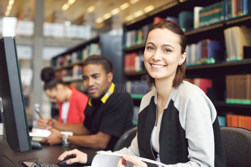 Piękna młoda kobieta przy bibliotecznym robi badaniem fotografia stock Piękna młoda kobieta przy bibliotecznym robi badaniem fotografia stock