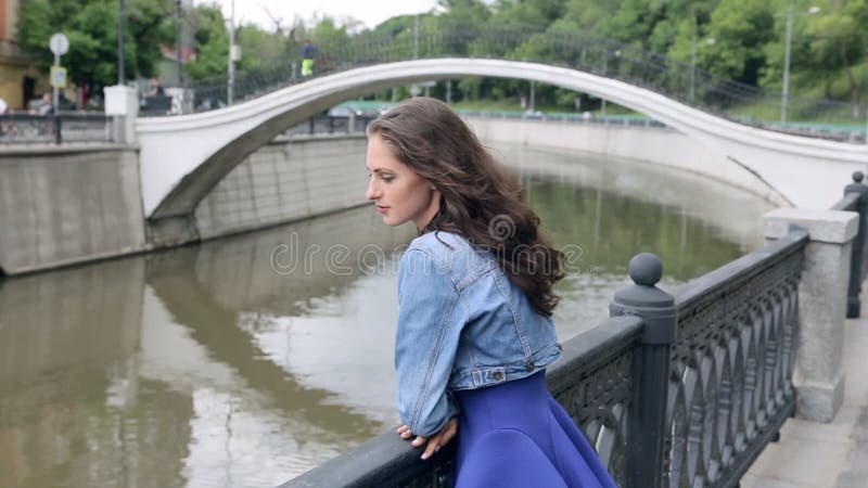Piękna młoda kobieta w błękit sukni stoi na brzeg rzekim