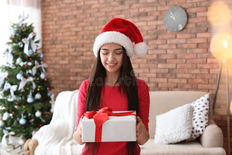 Piękna młoda kobieta w Santa kapeluszu z prezenta pudełkiem zdjęcia stock Piękna młoda kobieta w Santa kapeluszu z prezenta pudełkiem zdjęcia stock