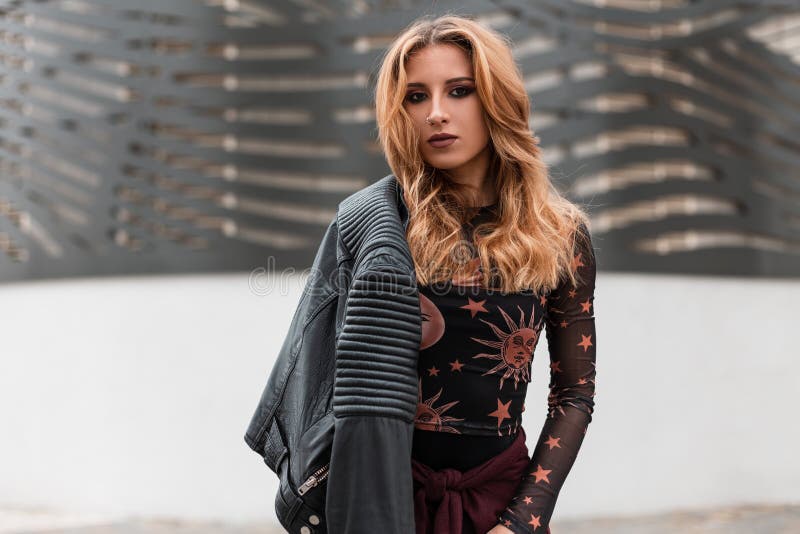 Piękna młoda kobieta z czerwonym włosy w kolczyku w nosie w rocznika czerni skórzanej kurtce w modnej bluzce z wzorem obrazy stock