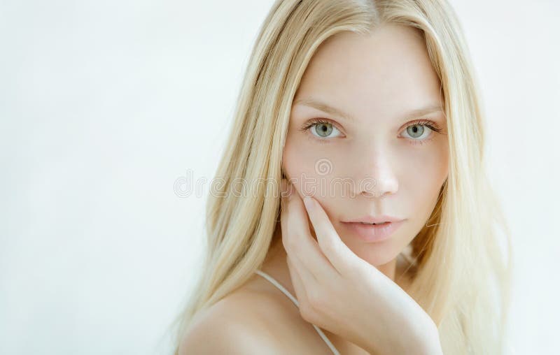 Beautiful young woman with clean fresh skin on light background. Beautiful young woman with clean fresh skin on light background