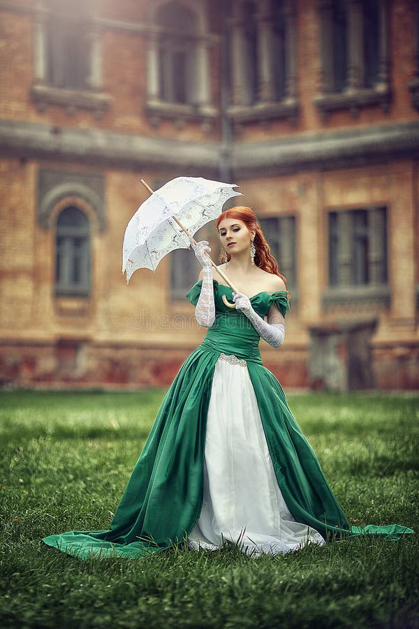 Piękna młoda miedzianowłosa dziewczyna w średniowiecznej zieleni sukni