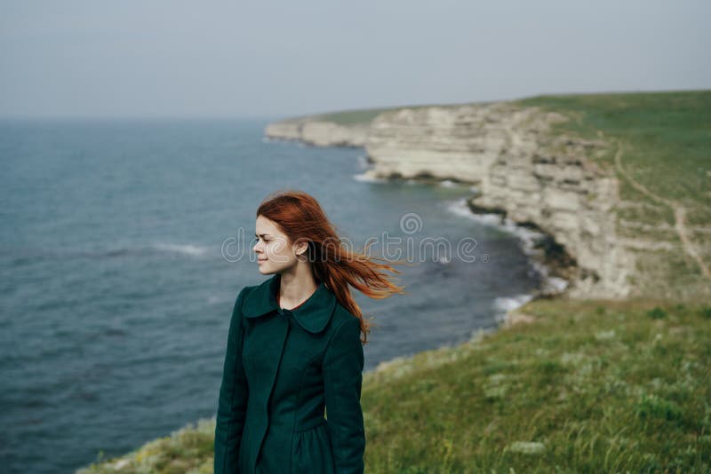 Piękna młodej kobiety pozycja na falezie góra blisko morza fotografia stock Piękna młodej kobiety pozycja na falezie góra blisko morza fotografia stock