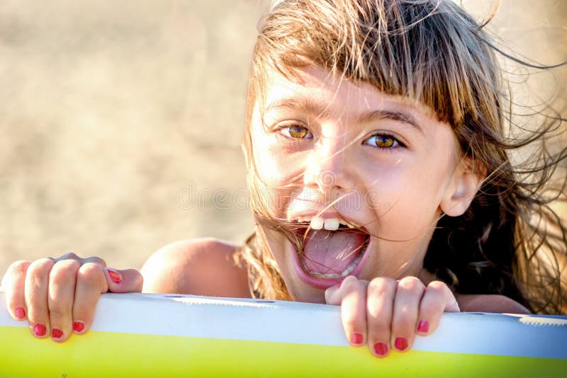 Piękna osiem roczniaka dziewczyna ono uśmiecha się na plaży fotografia royalty free Piękna osiem roczniaka dziewczyna ono uśmiecha się na plaży fotografia royalty free