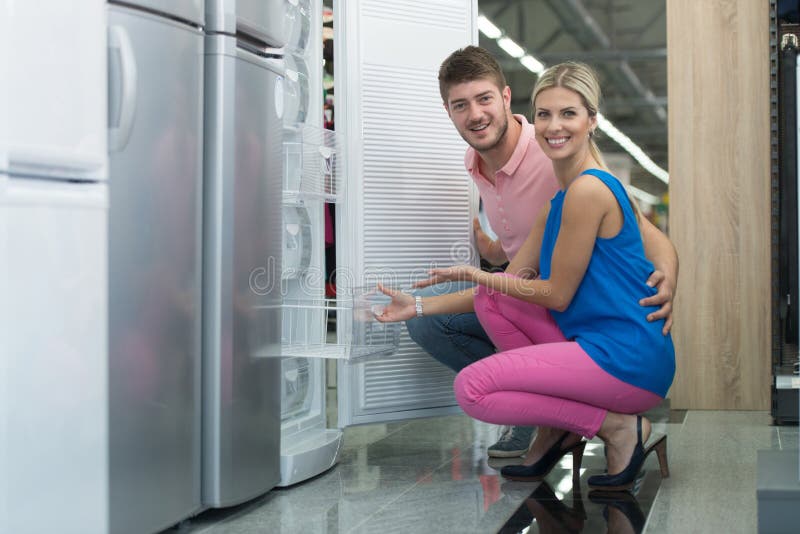 Piękna potomstwo para Robi zakupy Fridge W supermarkecie fotografia royalty free Piękna potomstwo para Robi zakupy Fridge W supermarkecie fotografia royalty free
