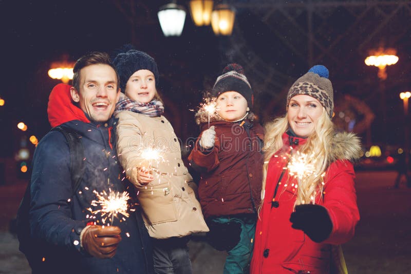 Piękna rodzina z płonącymi sparklers obrazy stock Piękna rodzina z płonącymi sparklers obrazy stock