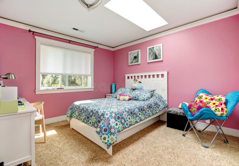 Gentle girls bedroom with white bed and pink walls. View of bed with blue bedding, blue chair. Gentle girls bedroom with white bed and pink walls. View of bed with blue bedding, blue chair