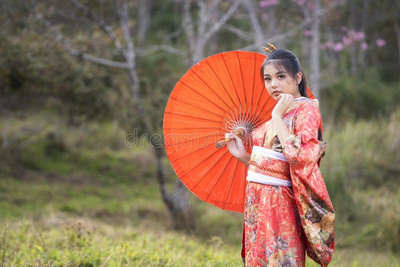Piękna samica w tradycyjnym japońskim kimono z wiśniowym kwitkiem w japonii obraz royalty free