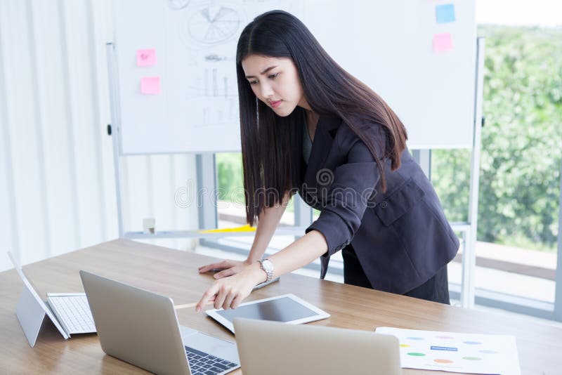 piękna Ufna azjatykcia młoda biznesowa kobieta pracuje laptop z wykresem i wskazuje na biurku pastylki i dokumentu zdjęcie stock piękna Ufna azjatykcia młoda biznesowa kobieta pracuje laptop z wykresem i wskazuje na biurku pastylki i dokumentu zdjęcie stock