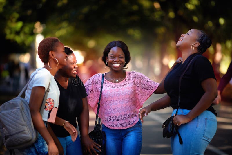 Beautiful african american women, laughing friends having fun while walking in the city park. Beautiful african american women, laughing friends having fun while walking in the city park