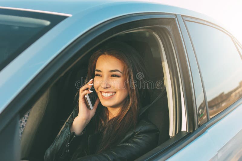 Pięknej brunetki kobiety długie włosy młody azjatykci jeżdżenie i mówienie telefonem komórkowym zdjęcia royalty free Pięknej brunetki kobiety długie włosy młody azjatykci jeżdżenie i mówienie telefonem komórkowym zdjęcia royalty free