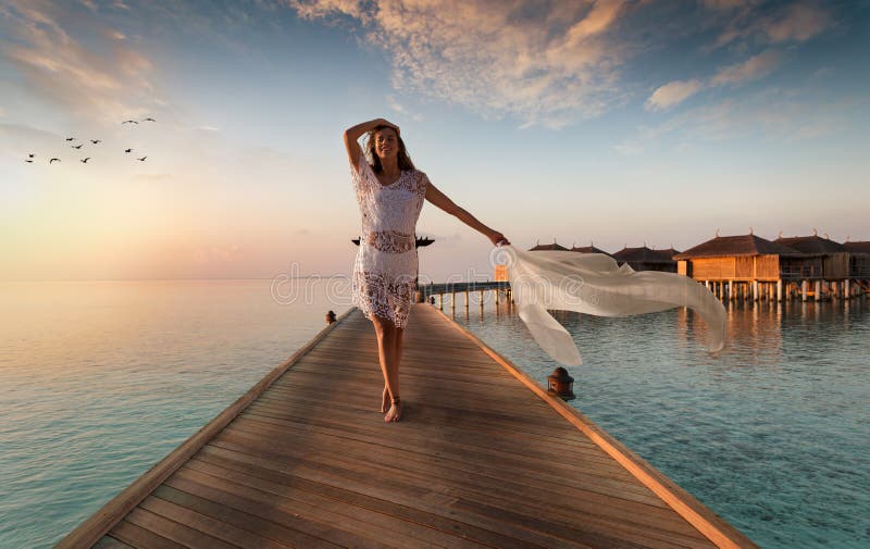 Piękni kobieta spacery zestrzelają drewnianego jetty na Maldives zdjęcia stock Piękni kobieta spacery zestrzelają drewnianego jetty na Maldives zdjęcia stock