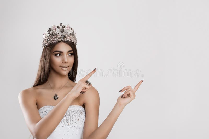 Piękno królowa wskazuje z jej palcami jej lewica puste miejsce kopii pusta przestrzeń fotografia royalty free Piękno królowa wskazuje z jej palcami jej lewica puste miejsce kopii pusta przestrzeń fotografia royalty free