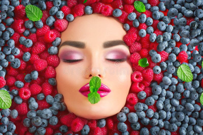 Piękno mody modela dziewczyny lying on the beach w świeżych dojrzałych jagodach Twarz w kolorowym jagody zbliżeniu Piękne makeup fotografia stock