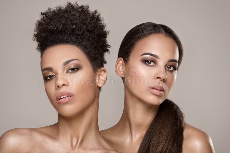 Two beauty young african american women. Closeup portrait of beautiful girls with natural makeup. Two beauty young african american women. Closeup portrait of beautiful girls with natural makeup.