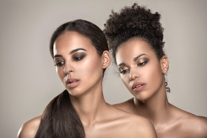 Two beauty young african american women. Closeup portrait of beautiful girls with natural makeup. Two beauty young african american women. Closeup portrait of beautiful girls with natural makeup.