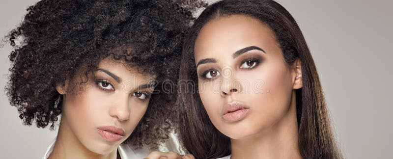 Two beauty young african american women. Closeup portrait of beautiful girls with natural makeup. Two beauty young african american women. Closeup portrait of beautiful girls with natural makeup.