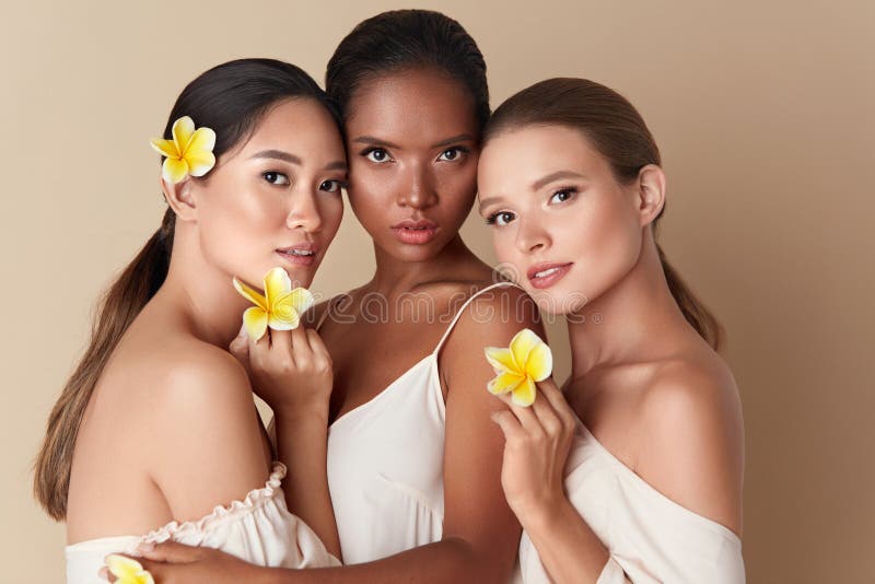 Beauty. Diverse Group Of Women Portrait. Tender Models Of Different Ethnicity Posing With Tropical Flowers In Hands. Asian, Mixed Race And Caucasian Female With Healthy Skin Holding Plumeria. Beauty. Diverse Group Of Women Portrait. Tender Models Of Different Ethnicity Posing With Tropical Flowers In Hands. Asian, Mixed Race And Caucasian Female With Healthy Skin Holding Plumeria