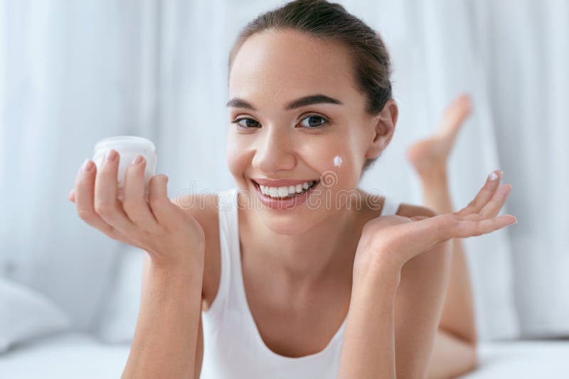 Beauty Face Cream. Beautiful Smiling Girl Applying Cosmetic Cream On Facial Skin Portrait. High Resolution. Beauty Face Cream. Beautiful Smiling Girl Applying Cosmetic Cream On Facial Skin Portrait. High Resolution