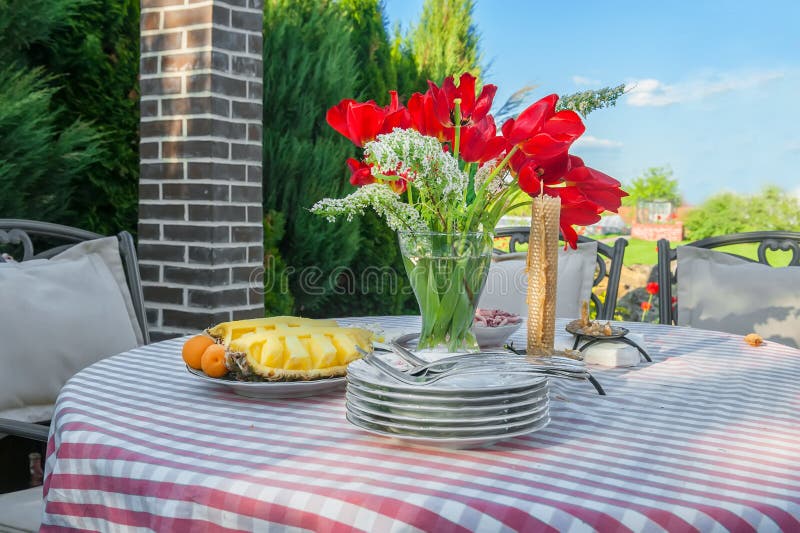 Piękny bukiet czerwoni tulipany w przejrzystej wazie na stole outdoors fotografia royalty free Piękny bukiet czerwoni tulipany w przejrzystej wazie na stole outdoors fotografia royalty free