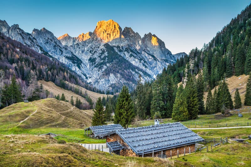 Beautiful landscape in the Alps with traditional mountain chalets and glowing summits in beautiful evening light, Nationalpark Berchtesgadener Land, Bavaria, Germany. Beautiful landscape in the Alps with traditional mountain chalets and glowing summits in beautiful evening light, Nationalpark Berchtesgadener Land, Bavaria, Germany.