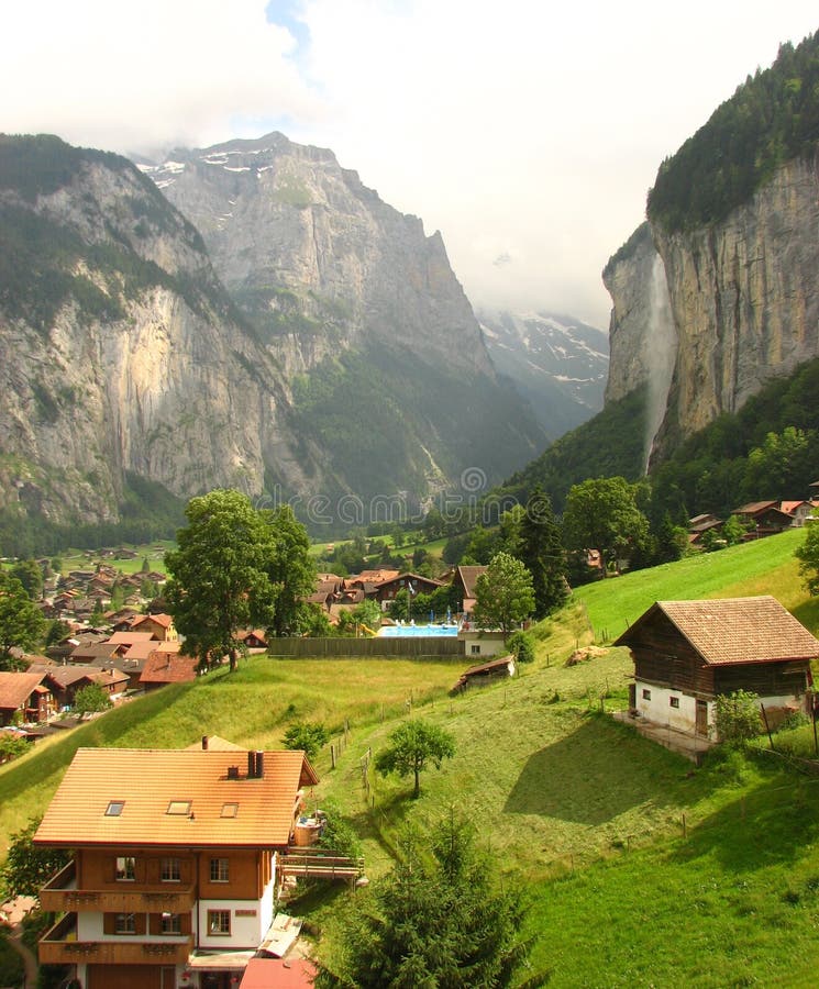 Beautiful Swiss valley with lush greenery and a waterfall and typical Swiss houses or chalets. i clicked this picture while visiting Lauterbrunnen, Switzerland. Beautiful Swiss valley with lush greenery and a waterfall and typical Swiss houses or chalets. i clicked this picture while visiting Lauterbrunnen, Switzerland