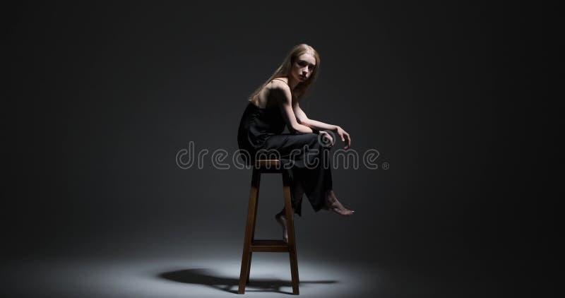Piękny model mody siedzący na wysokim stołku