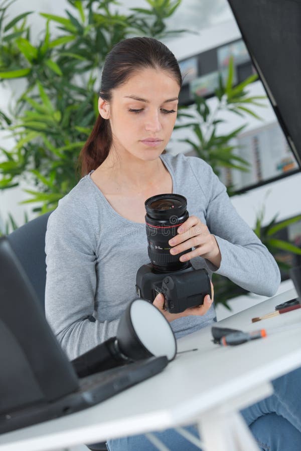 Piękny młody żeński fotograf sprawdza obrazki na kamerze zdjęcia royalty free Piękny młody żeński fotograf sprawdza obrazki na kamerze zdjęcia royalty free