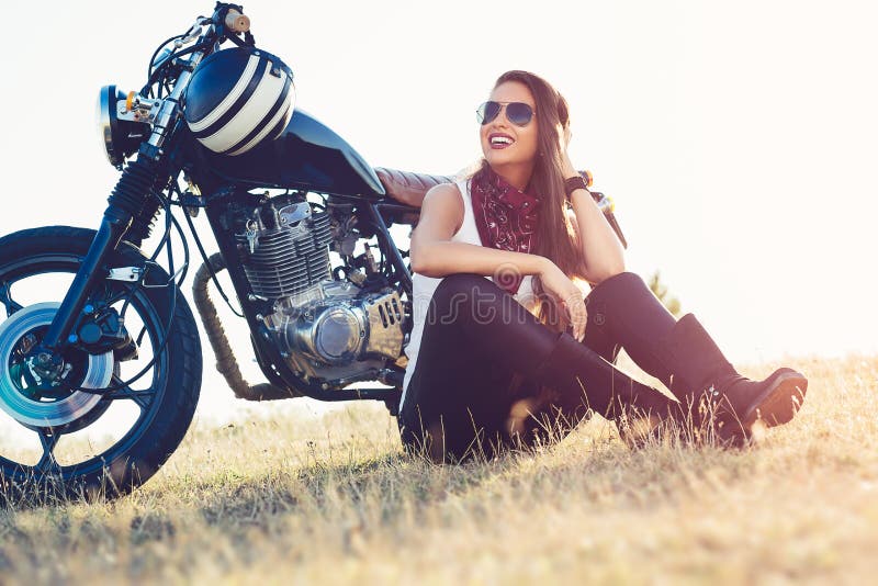 Piękny rowerzysta kobiety obsiadanie jej motocyklem na autostradzie zdjęcie royalty free Piękny rowerzysta kobiety obsiadanie jej motocyklem na autostradzie zdjęcie royalty free