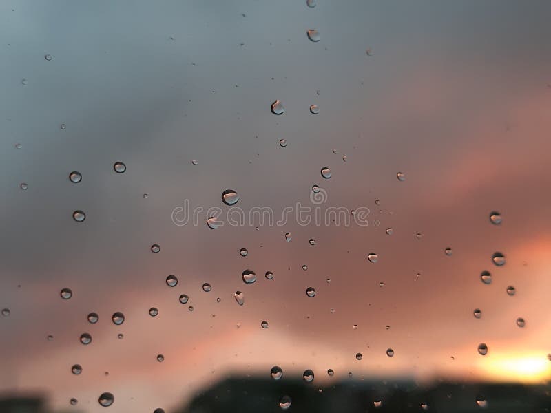 Genova, Italy - 01/17/2019: An incredible sunset over the city of genova after a huge rain and an amazing waterdrop effect over the windows with beautiful orange reflection. Genova, Italy - 01/17/2019: An incredible sunset over the city of genova after a huge rain and an amazing waterdrop effect over the windows with beautiful orange reflection