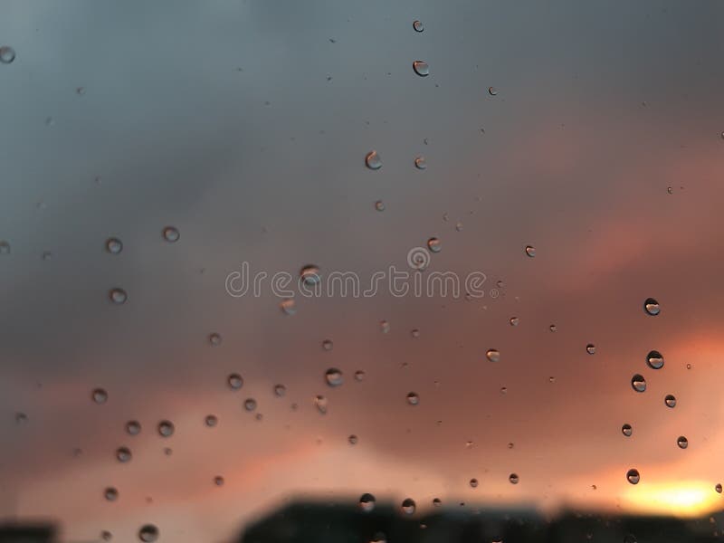 Genova, Italy - 01/17/2019: An incredible sunset over the city of genova after a huge rain and an amazing waterdrop effect over the windows with beautiful orange reflection. Genova, Italy - 01/17/2019: An incredible sunset over the city of genova after a huge rain and an amazing waterdrop effect over the windows with beautiful orange reflection